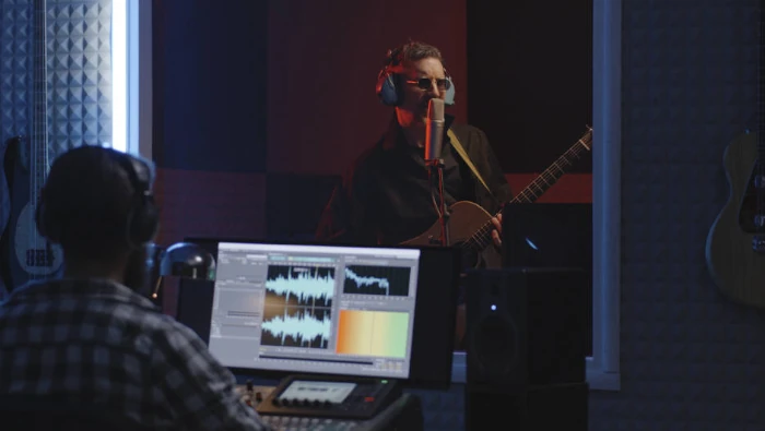 musician playing acoustic guitar at home studio