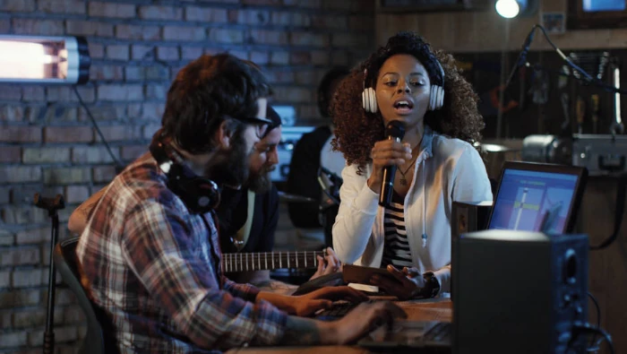 woman singing at microphone in a home studio