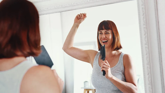 woman singing in front of a mirror