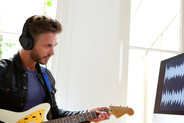 man playing guitar home studio